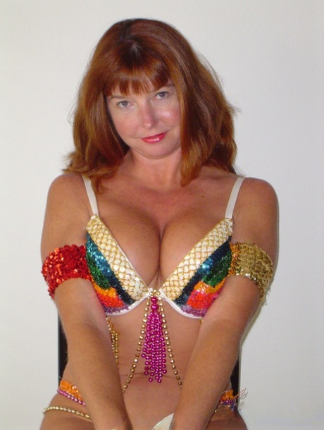 Hot mature Dee Delmar doffs her skimpy carnival costume to toy her twat
