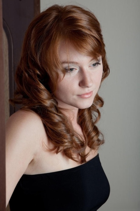Natural redhead Nomi pulls down and hikes up her black dress to show her wares