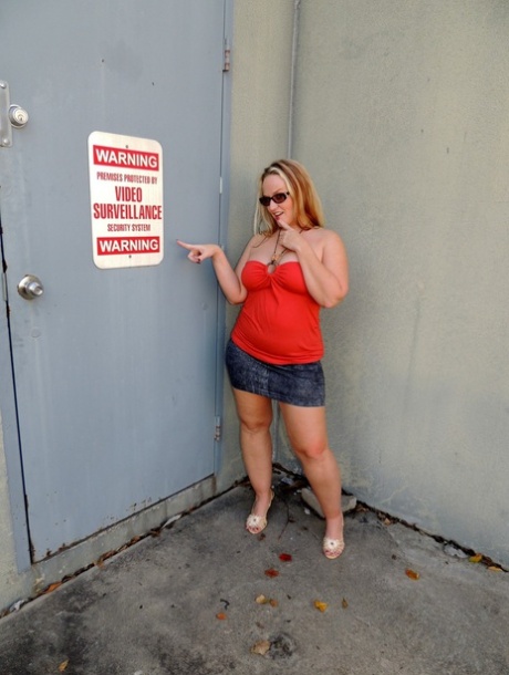 Overweight blonde Dee Siren dildos her snatch near a receiving door