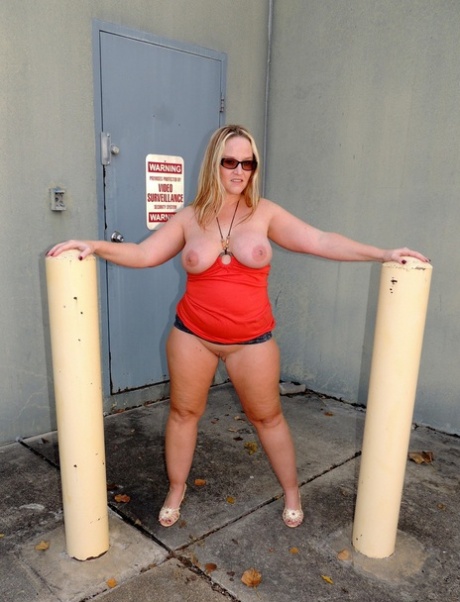 Overweight blonde Dee Siren dildos her snatch near a receiving door