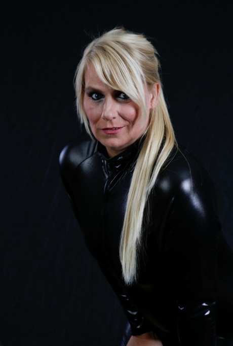 Mature blonde cups her small tits as she gets out of full body cat suit
