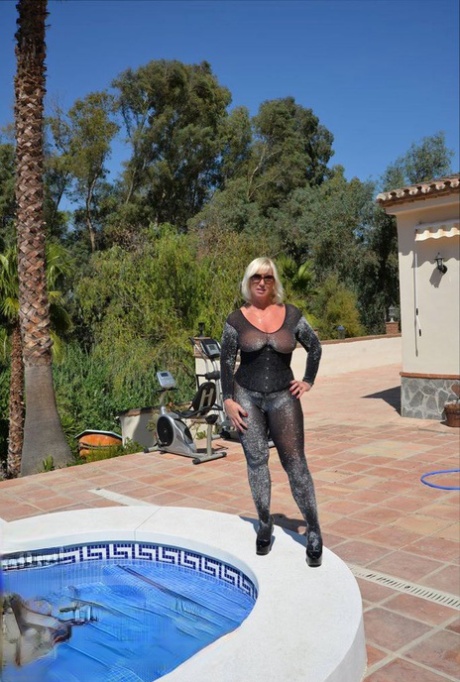 Aged amateur Melody takes off her heels before a swim in a bodysuit and shades