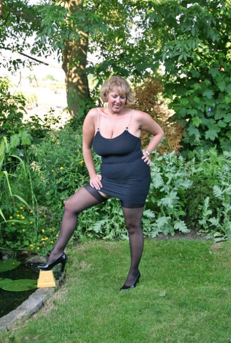 Fat older woman Curvy Claire sets her giant boobs loose in backyard