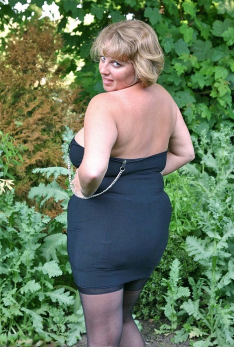Fat older woman Curvy Claire sets her giant boobs loose in backyard