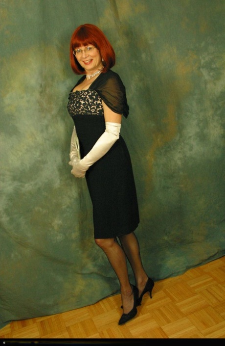 Older redhead Abigail Fraser exposes her boobs in a girdle and long gloves