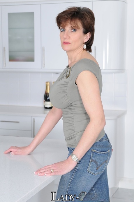 Mature wife Lady Sonia flaunts big tits braless in t-shirt in the kitchen