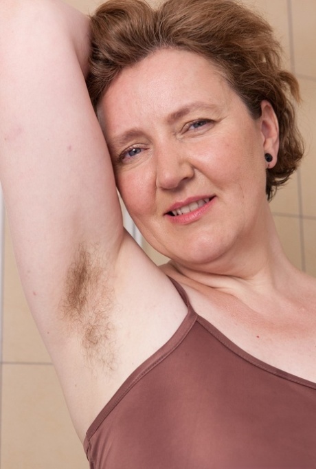 Mature fatty Romana Sweet shows off unshaven armpits and beaver in bathroom
