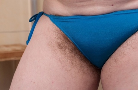 Mature fatty Romana Sweet shows off unshaven armpits and beaver in bathroom