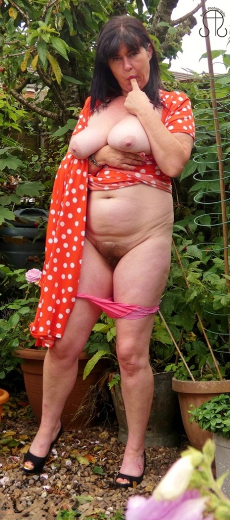 Busty UK lady Juicey Janey displays her full bush while reading a book