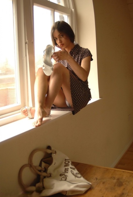 Pretty girl Steffi displays her tight ass after getting undressed by a window