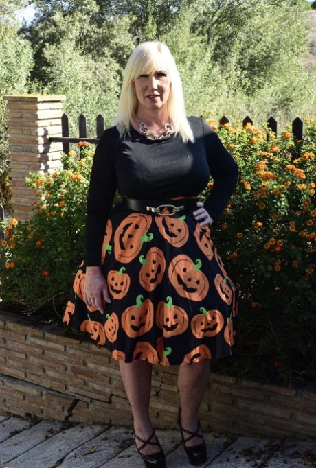Mature blonde Melody exposes her bra and panties while dressed for Halloween