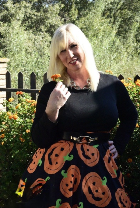 Mature blonde Melody exposes her bra and panties while dressed for Halloween