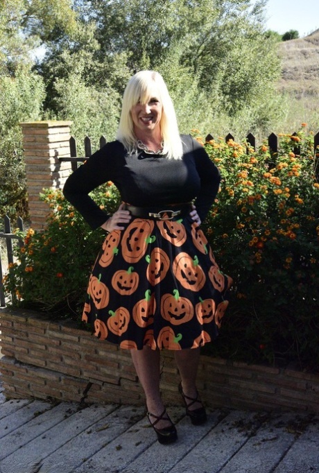 Mature blonde Melody exposes her bra and panties while dressed for Halloween