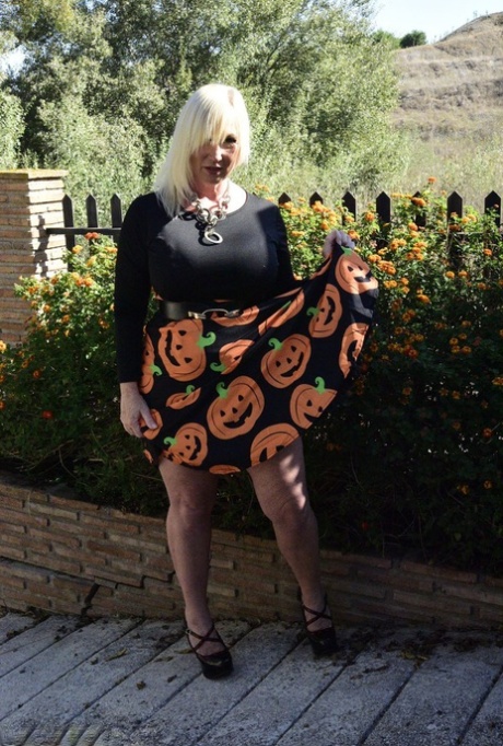 Mature blonde Melody exposes her bra and panties while dressed for Halloween