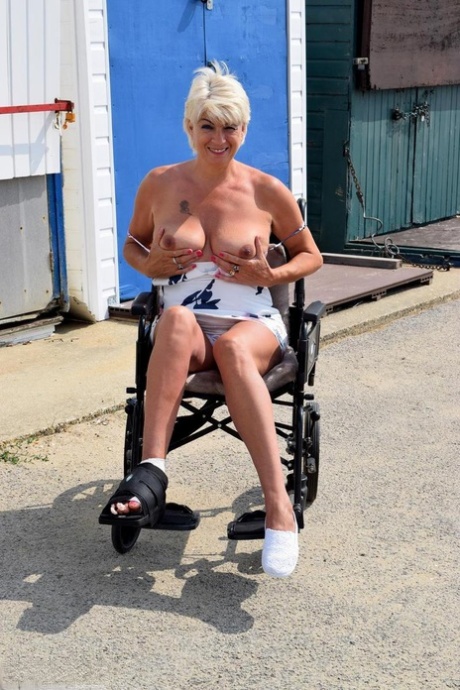 Mature blonde Dimonty gets totally naked while sporting an injured foot