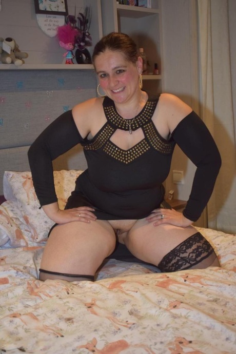 Middle-aged BBW gets completely naked on top of her bed for her first nudes