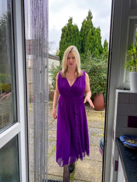 Mature blonde Laura Chalice doffs a long dress before fondling her tits & twat