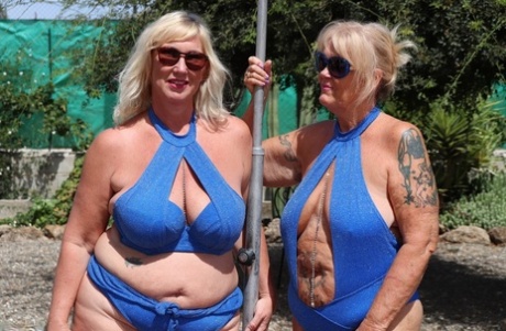 Overweight mature blonde lesbians fool around with each other in a backyard