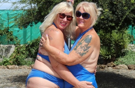 Overweight mature blonde lesbians fool around with each other in a backyard