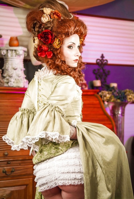 Glamorous redhead lady in white stockings uncovering her tattooed body