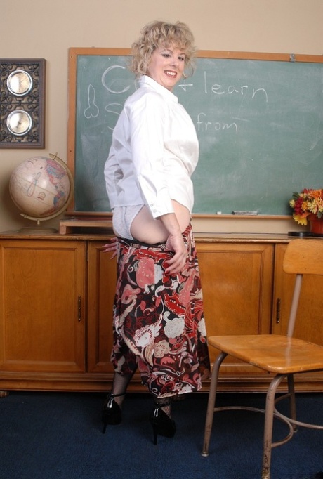 Stocking clad older blonde teacher strips in classroom to spread bald cunt