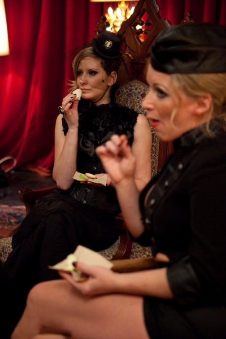 Kinky mistresses in elegant dresses play with their tied up sex slaves