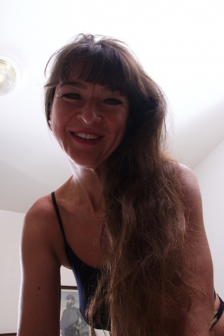 Mature brunette Gabrellia reveals her tasty clam and hot ass on a bed
