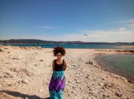 Mature ebony with hairy armpits Divine reveals her bushy cunt on the beach