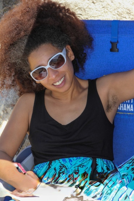 Mature ebony with hairy armpits Divine reveals her bushy cunt on the beach