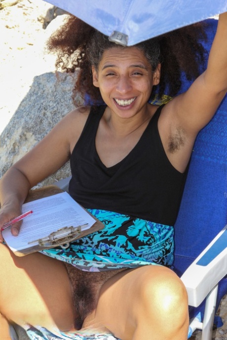 Mature ebony with hairy armpits Divine reveals her bushy cunt on the beach