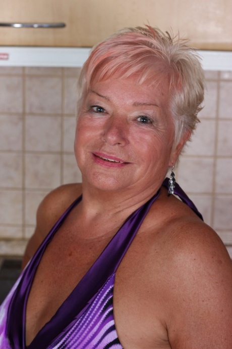 Short haired granny Verona M strips in the kitchen and fingers her old snatch