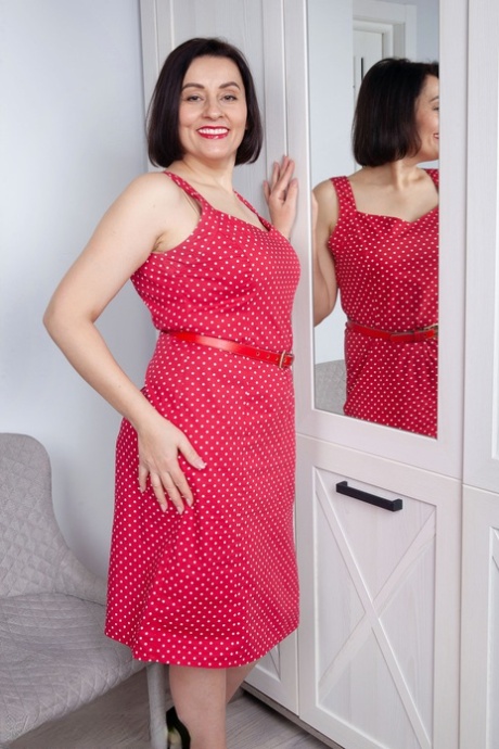 Mature amateur Allegra removes her red dress & flaunts her big tits & holes