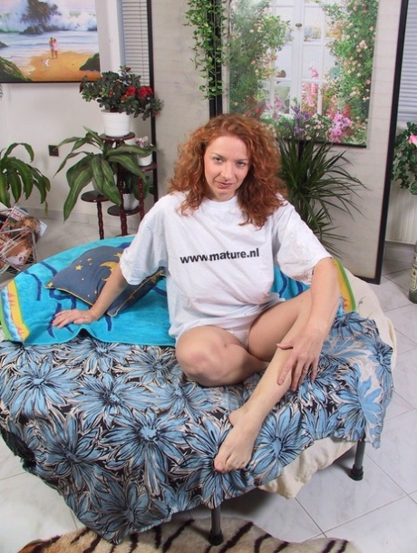 Curly-haired housewife Carol servicing her horny pussy with a massive dildo