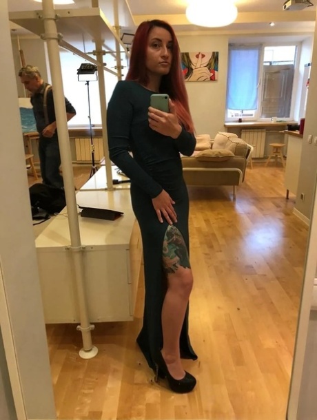 Pretty redhead teases with her lovely tits and inked body in the mirror