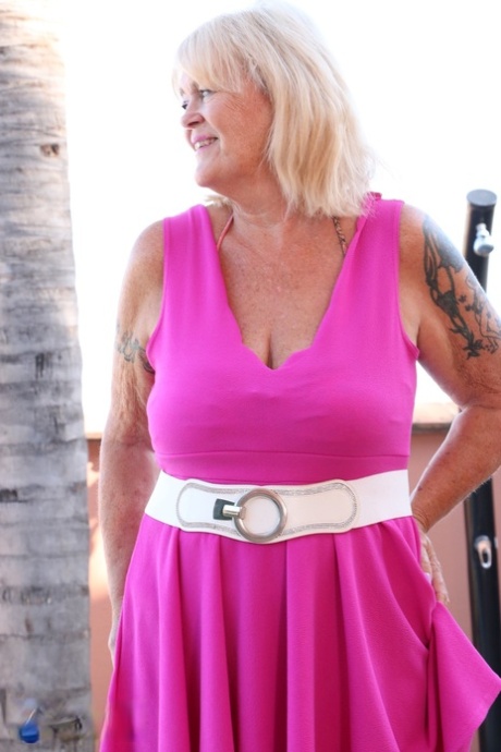 British granny Randy Raz unveils her big tits & flashes her panties outside